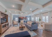 Thumbnail 3 of 25 - Clubhouse living room with couches, chairs, t.v., and a kitchen in the background