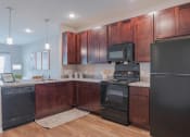 Thumbnail 16 of 25 - A kitchen with dark wood cabinets and black appliances