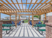 Thumbnail 6 of 25 - Crossing at Grove Citys clubhouse patio with green picnic tables