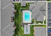 Thumbnail 33 of 34 - A bird's eye view of a residential area with houses, a swimming pool, and a parking lot.
