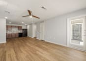 Thumbnail 8 of 50 - A room with a ceiling fan and wooden flooring.