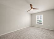 Thumbnail 13 of 50 - A room with a ceiling fan and a window showing a building outside.