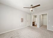Thumbnail 11 of 50 - A room with a ceiling fan and a carpeted floor.