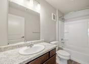 Thumbnail 18 of 50 - A white bathroom with a sink, toilet, and bathtub.