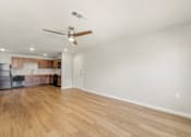 Thumbnail 2 of 50 - A room with a ceiling fan and wooden flooring.