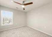 Thumbnail 12 of 50 - A room with a ceiling fan and a window with blinds.