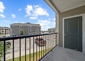 Thumbnail 21 of 50 - A balcony with a black railing and a grey door.