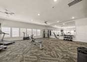 Thumbnail 33 of 50 - A spacious gym with treadmills, elliptical machines, and other exercise equipment.