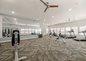 Thumbnail 32 of 50 - A spacious gym with a variety of exercise equipment and a ceiling fan.