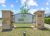 Thumbnail 47 of 50 - A green sign with the name "AGAVEEAST" is mounted on a stone pillar.