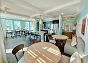 Thumbnail 14 of 34 - a community kitchen with a bar and kitchen appliances at flats at sundown apartments in north port florida