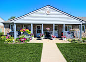 Thumbnail 1 of 13 - the front of Frankfort Place apartments clubhouse with flowers on the porch