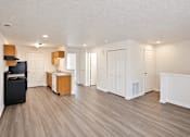 Thumbnail 7 of 14 - A room with white walls and wooden floors has a flat screen TV and a wooden cabinet.