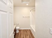 Thumbnail 18 of 19 - A white bathroom with a toilet and a shower.