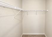 Thumbnail 7 of 19 - A white closet with a shelf and a carpeted floor.