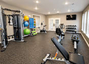 Thumbnail 10 of 19 - A well-equipped home gym with a variety of exercise equipment.