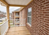 Thumbnail 6 of 19 - A balcony with a white railing and a brick wall.