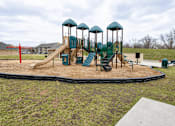Thumbnail 9 of 19 - A playground with a green slide and a brown sandbox.