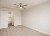 Thumbnail 5 of 21 - A room with a ceiling fan and carpeted floor.