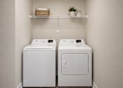 Thumbnail 10 of 21 - Two white washing machines in a laundry room.