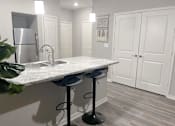 Thumbnail 23 of 31 - a kitchen with a marble counter top and a stainless steel refrigerator