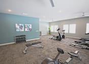 Thumbnail 18 of 24 - A gym with a variety of equipment including weights, a bench, and a treadmill.