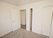 Thumbnail 8 of 11 - a bedroom with two closets and a door to a hallway