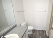 Thumbnail 10 of 11 - a bathroom with a toilet and a sink and a mirror