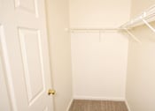 Thumbnail 11 of 11 - a walk in closet with a white closet door and a door to a closet