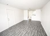 Thumbnail 4 of 11 - an empty living room with white walls and wood flooring