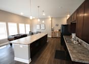Thumbnail 18 of 20 - A kitchen with a large island in the middle of the room.