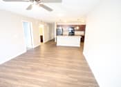 Thumbnail 1 of 20 - A spacious room with a ceiling fan and wooden flooring.
