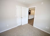 Thumbnail 4 of 20 - A room with a white door and carpeted floor.