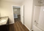 Thumbnail 7 of 20 - A bathroom with a white tub and a sink.