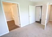 Thumbnail 3 of 20 - A room with three open doors and a carpeted floor.