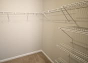Thumbnail 9 of 20 - Empty shelves in a room with white walls and brown carpet.
