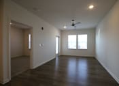 Thumbnail 13 of 28 - an empty living room with wood floors and a ceiling fan