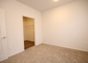 Thumbnail 20 of 28 - a bedroom with white walls and carpet and a closet
