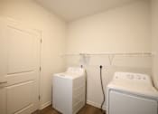 Thumbnail 9 of 28 - a white washer and dryer in a laundry room with a white door