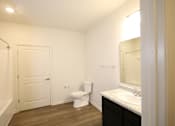 Thumbnail 16 of 28 - a bathroom with a toilet and a sink and a mirror