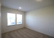 Thumbnail 23 of 28 - a living room with white walls and two windows