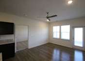 Thumbnail 10 of 28 - an empty living room with wood floors and a ceiling fan