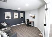 Thumbnail 8 of 25 - A room with a black chair and a small table.