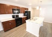 Thumbnail 14 of 25 - A kitchen with a black refrigerator and stove.