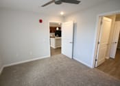 Thumbnail 16 of 25 - A room with a carpeted floor and a ceiling fan.