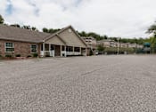 Thumbnail 1 of 24 - A house with a grey roof and a driveway in front.