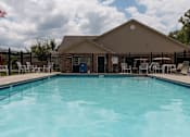 Thumbnail 7 of 24 - A pool in front of a building with a flag on the left.