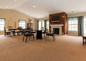 Thumbnail 5 of 24 - A large room with a fireplace and a TV on the wall.