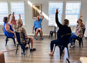 Thumbnail 52 of 58 - a group of people sitting in a circle with their hands up in a class room