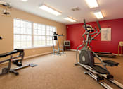 Thumbnail 10 of 24 - A home gym with a treadmill, elliptical trainer, and other exercise equipment.